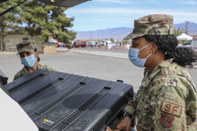 Senior Airman Traesha Glover (right) and Spc. Graciela Gomez load essential supplies into an emergency response vehicle at the mobile vaccination unit site, Thursday, April 8, 2021 in Pahrump, Nevada.