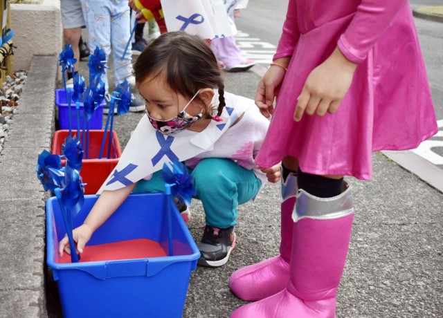 Cali Horilcoshi, 3, plants a pinwheel at the Child Development Center at the Sagamihara Family Housing Area, Japan, April 9. Camp Zama Family and Morale, Welfare and Recreation officials held a superhero parade and the pinwheel planting in honor...