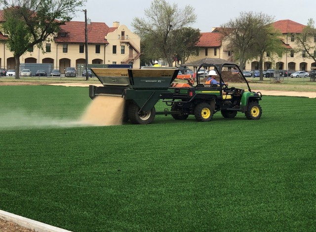 FORT SILL, Okla., April 14, 2021 -- Pro Turf Incorporated worker Carlos Nambo lays down fine sand onto the new artificial turf field near the corner of Randolph Road and Fort Sill Boulevard. PWE Incorporated of Lawton was the lead contractor for the project completing all dirt moving and grading along with concrete work. PATCO Electric of Lawton will install light poles to illuminate the field. 