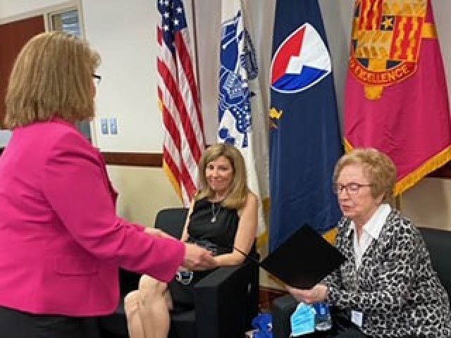 Annette Riggs (left), Deputy Chief of Staff U.S. Army Tank-automotive and Armaments Command, presents a Star Note to Sophie Klisman, Holocaust survivor and keynote speaker, in appreciation for participating in TACOM’s Holocaust Remembrance Day Observance at the Detroit Arsenal, Michigan Apr. 13.  Riggs also presented Star Notes to Lori Klisman Ellis and Dr. Doug Harvey who also participated in the event. (Photo by Paul Lechner)