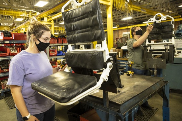 Robin Hurst (left) and Evelyn Wilke, student trainee laborers in the Pathways Technical College program, reassemble troop seats for a Stryker vehicle.