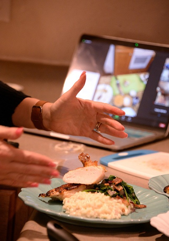 Fort Leavenworth Spouses’ Club cooking class participant Liz Stone, FLSC special events chairperson, finishes plating her herb-roasted chicken main dish with side dishes of parmesan and herb risotto and baby spinach and bacon sauté during the...