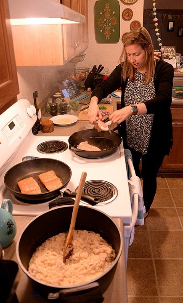 Fort Leavenworth Spouses’ Club cooking class participant Liz Stone, FLSC special events chairperson, adds a chicken breast to a hot pan during the Zoom-based class April 6 at her on-post home. Cooking class participants cooked chicken and salmon...