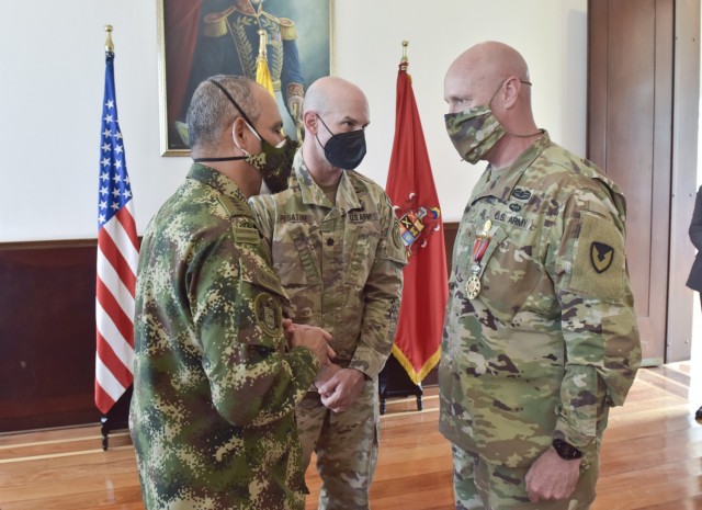 Gen. Eduardo Zapateiro, the Colombian National Army commanding general, presents the 'Faith in the Cause' medal to Brig. Gen. Douglas Lowrey, commander of U.S. Army Security Assistance Command, at the Canton Norte base in Bogota, Colombia, 8 April 2021. Lt. Col. Andrew Pesature, center, Army Chief of Missions at U.S. Embassy, translates Gen. Zapateiro’s words. This medal was created to honor members of the Colombian Army who have been distinguished for their outstanding service, as well as to honor foreign military members who have earned the gratitude of the national army of Colombia. Brig. Gen. Lowrey was presented the medal as the leader of an organization that has been a critical component to the success and modernization of the Colombian Army over the past decades. (U.S. Army photo by Richard Bumgardner)