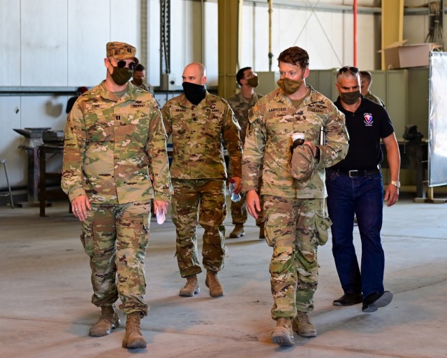 U.S. Army Capt. Stephen Long, executive officer, 401st Army Field Support Battalion-Qatar (left), guides Col. Michael F. LaBrecque, commander, 401st Army Field Support Brigade, and AFSBn-Qatar leadership through an empty warehouse during a 401st...