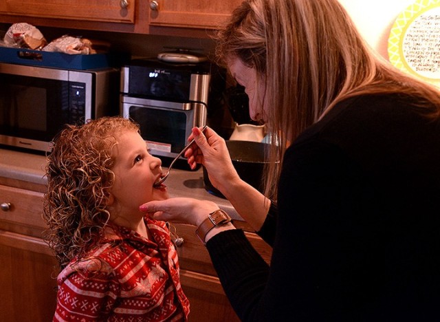 Fort Leavenworth Spouses’ Club cooking class participant Liz Stone, FLSC special events chairperson, offers a taste of risotto to her 5-year-old daughter, Ann Kathryn, while making the dish in the Zoom-based class April 6 at her on-post home....