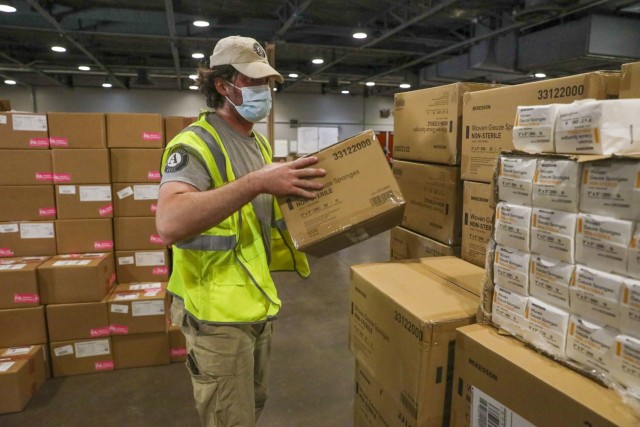 John Sandberg, a volunteer worker with AmeriCorps National Civilian Community Corps, loads supplies in a warehouse at the Fair Park Community Vaccination Center in Dallas, April 7, 2021. Sandberg, a New Haven, Connecticut, native, worked with the...