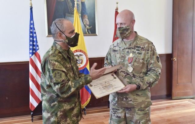 Gen. Eduardo Zapateiro, the Colombian National Army commanding general, presents the 'Faith in the Cause' medal to Brig. Gen. Douglas Lowrey, commander of U.S. Army Security Assistance Command, at the Canton Norte base in Bogota, Colombia, 8 April 2021. This medal was created to honor members of the Colombian Army who have been distinguished for their outstanding service, as well as to honor foreign military members who have earned the gratitude of the national army of Colombia. Brig. Gen. Lowrey was presented the medal as the leader of an organization that has been a critical component to the success and modernization of the Colombian Army over the past decades. (U.S. Army photo by Richard Bumgardner)