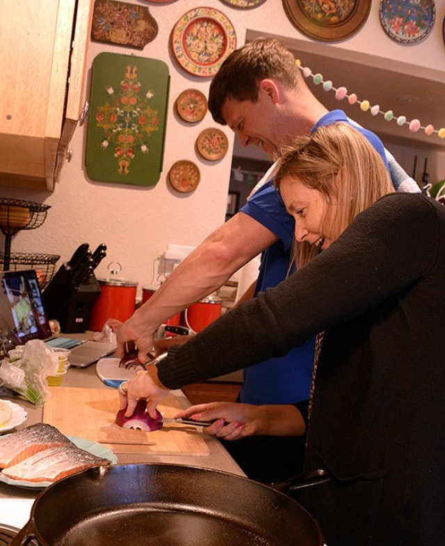 Maj. Ryan Stone, Command and General Staff Officer Course student, and Liz Stone, Fort Leavenworth Spouses’ Club special events chairperson, chop onions under the direction of Chef Jason Wiggin, owner of The Suburban in Leavenworth, via Zoom...