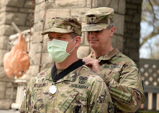 Catholic Chaplain (Maj.) Jason Hesseling, Combined Arms Doctrine Directorate religious support integrator, receives the Order of Martin of Tours medallion from Garrison Chaplain (Col.) Michael McDonald during a ceremony April 9 at Zais Park. The...