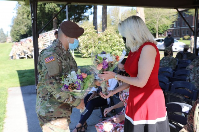 Jennifer Taylor, spouse of Brig. Gen. Curtis Taylor, receives a bouquet of roses during 5th Security Force Assistance Brigade's Relinquishment of Command, April 16, 2021.  Brig. Gen. Taylor takes command at the National Training Center at Fort Irwin, California next week.