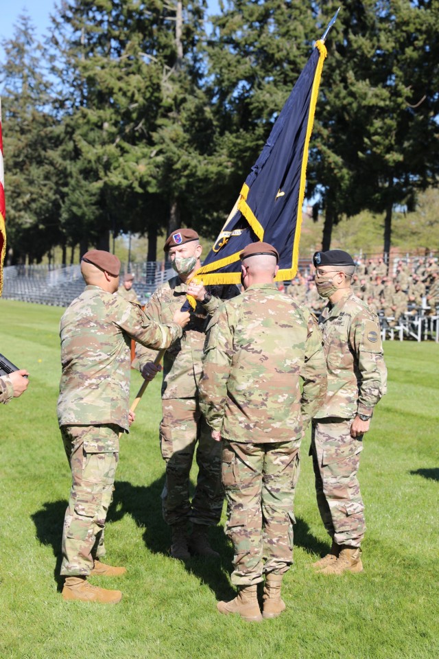 Brig. Gen. Curtis Taylor receives the colors of 5th Security Force Assistance Brigade from Brigade Command. Sgt. Maj. Rob Craven at Watkins Field, Joint Base Lewis McChord before passing them to Lt. Gen. Leopoldo Quintas, Deputy Commanding General, U.S. Army Forces Command. Taylor takes command at the National Training Center at Fort Irwin, California next week.