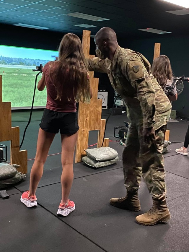 Staff Sgt. Omar Smith, a task instructor from 904th Contracting Battalion,
instructs a tour participant in basic rifle marksmanship at the Engagement
Skills Trainer, April 8 on Fort Stewart, Georgia.