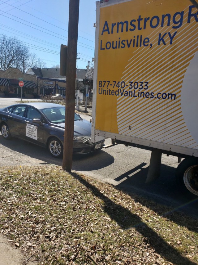 A quality control inspector’s vehicle sits behind a moving truck as it’s filled with a Soldiers household goods. Inspectors physically visit Families’ homes during a move to provide support and look out for any problems.