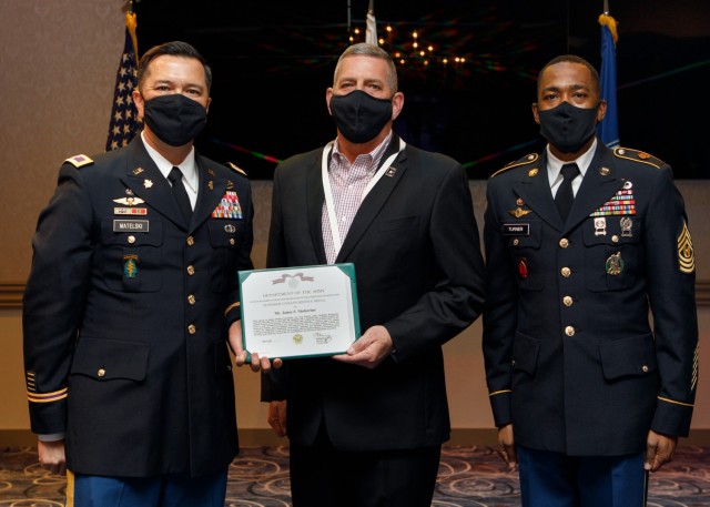 U.S. Army Garrison Japan commander Col. Thomas Matelski (left) and Command Sgt. Major Justin Turner (right) present J. Steve Niederriter, outgoing Deputy Garrison Commander, with the Superior Civilian Service Award during a retirement ceremony...