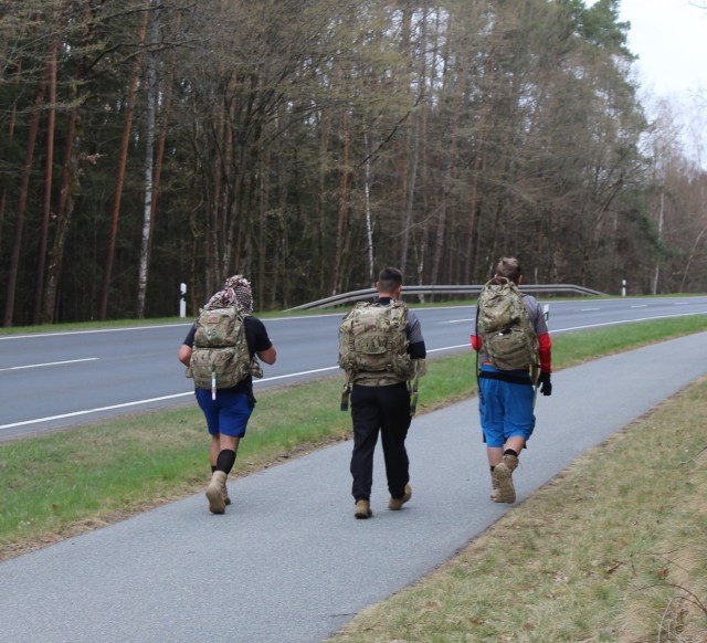 1st Lt. Nicholas Heckman, 2nd Lt. Joey Swink and Staff Sgt. Yonthan Roblesbarrios with 1st Battalion, 77th Field Artillery Regiment ruck march 26.2 miles in eight hours across Grafenwoehr, Germany on April 17, 2021 as part of the 32nd Annual Bataan Death March-Virtual Edition. (Official U.S. Army photo by Capt. Paul Dyer)