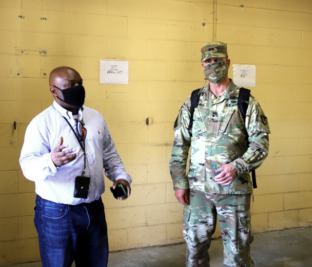 Fort Stewart, Ga - Kevin Lewis, chief, Installation Supply Division, 406th Army Field Support Battalion (left), shows Maj. Gen. Daniel Mitchell, commanding general, U.S. Army Sustainment Command, one of the rooms that will be used to temporarily...