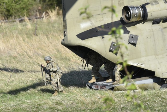 Trainees assigned to Company A, 35th Engineer Battalion, disembark from a CH-47 Chinook helicopter near Training Area 250 during a field training exercise last week. They also participated in a 12-mile ruck march and a cresting ceremony during their final and culminating week of training.