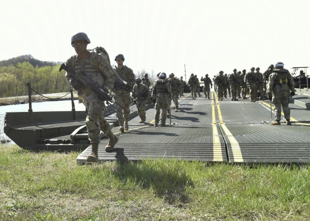 Combat engineer trainees from Company A, 35th Engineer Battalion, depart a float bridge after crossing the lake at Training Area 250 as part of their culminating field training exercise.