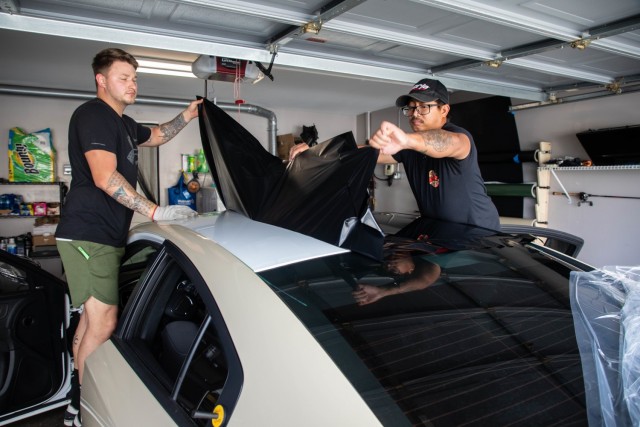 Spc. Billie Underwood and Lynard Jabonete pull vinyl wrap off of a vehicle in order to reset the vinyl wrap on April 16, 2021 in Ewa Beach, Hawaii. Underwood is a native of Kansas City, Missouri.