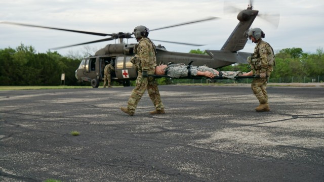 Task Force Phoenix crew chief Staff Sgt. William Hallgren and flight medic Staff Sgt. Tara Sawyer from G Company, 1st Battalion, 168th Aviation Regiment (General Support Aviation Battalion) carry a simulated patient during a MEDEVAC training mission that was part of a Culminating Training Exercise at North Fort Hood, Texas, April 17, 2021. 