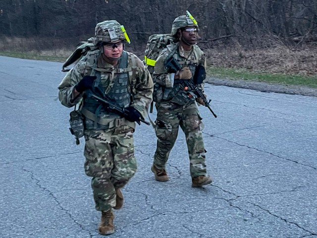 Spc. James Spoerl, human resources specialist, 1st Theater Sustainment Command, and Staff Sgt. Nahjier Williams, public affairs noncommissioned officer, 1st TSC, motivate each other towards the finish line of a 12 mile ruck march during the Best Warrior Competition, at Fort Knox, Kentucky, April 1, 2021. The Best Warrior Competition challenges Soldiers of all ranks to display their knowledge of Soldier competencies through a series of physical and mental challenges. (U.S. Army photo by Staff Sgt. Godot G. Galgano, 1st TSC Public Affairs)