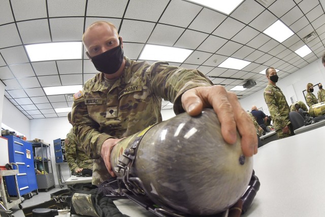 Spc. Brian McClure inspects the oxygen tank of the self-contained breathing apparatus during 88K Watercraft Operator Course training April 16 at the Transportation School’s Maritime and Intermodal Training Department.
