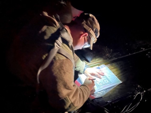 Spc. James Spoerl, human  resources specialist, 1st Theater Sustainment Command, plots points for night land navigation during the Best Warrior Competition at Fort Knox, Kentucky, March 31, 2021. The Best Warrior Competition challenges Soldiers of all ranks to display their knowledge of Soldier competencies through a series of physical and mental challenges. (U.S. Army photo by Staff Sgt. Godot G. Galgano, 1st TSC Public Affairs)