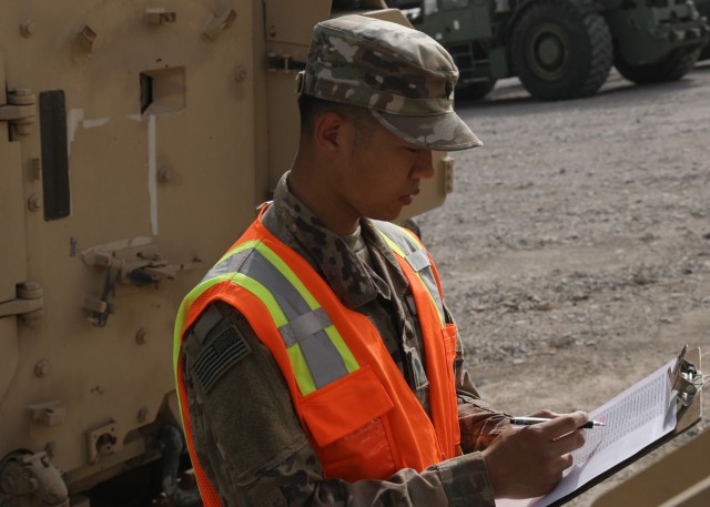 Army Reserve Spc. Feiyu He, a yard specialist deployed to Camp Arifjan, Kuwait, with the Lancaster, Pennsylvania-based 1185th Deployment and Distribution Support Battalion, reviews paperwork March 26, 2021 for rolling stock at Kuwait's Shuaiba...