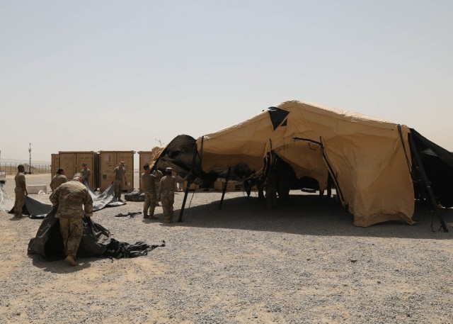 Soldiers deployed to Camp Arifjan, Kuwait, from the Fort Knox, Kentucky, based 1st Theater Sustainment Command, pitch tents April 12, 2021 at the maintenance yard established in conjunction with 1st TSC's expeditionary command post validation exercise. The ECP exercise validated the 1st TSC's "Blackjack" Soldiers' ability to continue operations at the camp or elsewhere in the U.S. Central Command area of responsibility in the event the current 1st TSC operational command post at the camp was inoperative. (U.S. Army photo by Staff Sgt. Neil W. McCabe)