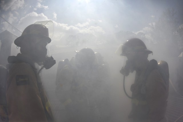 Watercraft operator students - silhouetted against a smoky backdrop -- wait for further instructions on the upper level of the fire trainer during firefighter training April 16 at the Transportation School facility located at Joint Base...