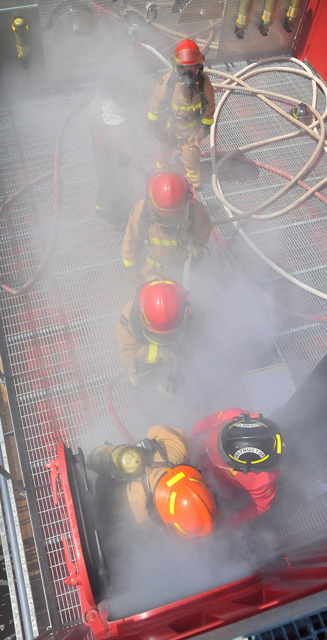 A team of Soldiers enter the upper level chamber of the fire trainer to locate and extinguish flames during 88K Watercraft Operator Course training April 16 at Joint Base Langley-Eustis.