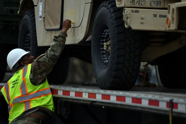 Spc. Onerray Neal, 842nd Transportation Battalion cargo specialist, marks a vehicle in a staging yard outside the Port of Port Arthur, Texas with stow plan info. The vehicle is one of many heading to Europe via ship in support of DEFENDER_Europe 20.  This exercise s the first in a series of exercises the U.S. Army has planned in Europe and the Pacific over the next five years. (U.S. Army photo/Kimberly Spinner)