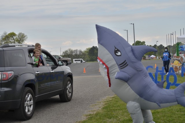 Fort Campbell children smile and wave at a friendly shark from an aquatic-themed Parent Central Services display April 17 during Kidsfest: Magical Drive-thru, hosted by Morale, Welfare and Recreation at the division parade field. Families traveled...