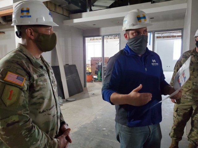 Command Sgt. Maj. Raymond Harris, the 1st Infantry Division senior enlisted leader toured the Junction City High School construction project April 9, 2021.  Cody Simon, wearing the Hutton Construction shirt, is the general superintendent with Hutton Construction and explained the engineering that went into the project. Several cement walls were cast on-site and hoisted into place with a crane, saving the district on transportation and the cost of off-site labor.