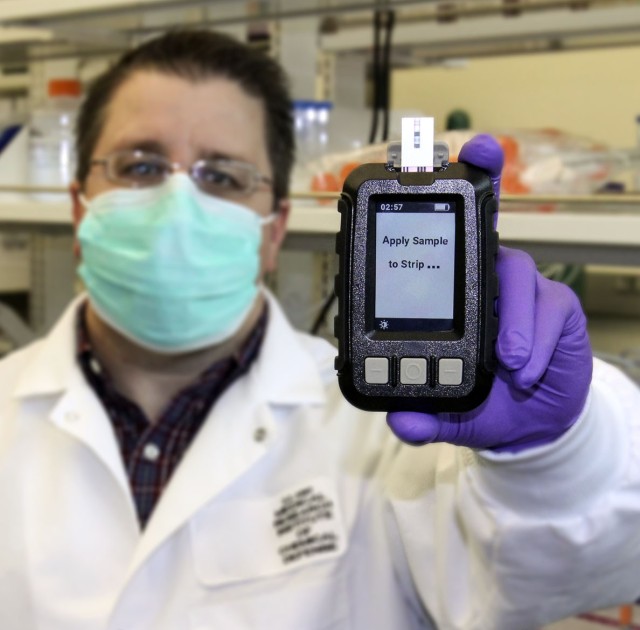 PHOTO CAPTION:  USAMRICD’s Dr. Shane Kasten holds the ruggedized prototype of his ChemDx Test System, an ultra-portable, easy-to-use device to provide early warning of suspected exposure to a chemical warfare nerve agent. 