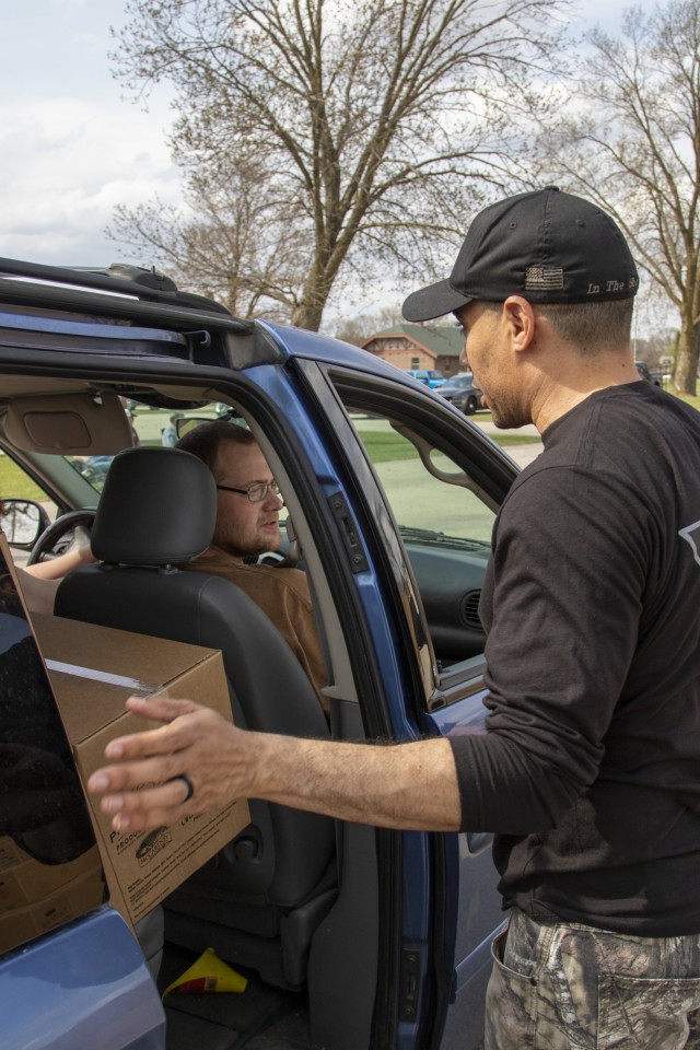 Capt. Natanael Maria, a logistics officer with 1st Battalion, 291st Brigade Support Battalion, 181st Multifunctional Training Brigade, finishes delivering a a United States Department of Agriculture Food Box to a Sparta, Wis., community member...