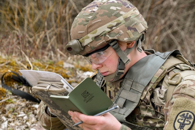 U.S. Army 1st Lt. Paige Runco, assigned to Landstuhl Regional Medical Center, plots coordinates during the MEDDAC Bavaria Best Warrior Competition at the Grafenwoehr Training Area, Germany, April 11, 2021. Competitors were tested for agility, mature judgement, physical fitness, warrior skills, land navigation and overall knowledge of medical, technical and tactical proficiencies through a series of hands-on tasks in a simulated operational environment. (U.S. Army photo by Spc. Denice Lopez)