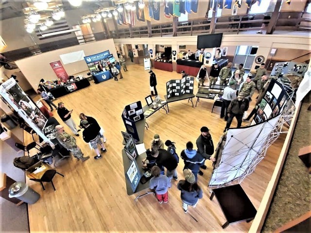 Visitors to the 2019 Fort McCoy Armed Forces Day Open House look over displays in building 905 on May 18, 2019, at Fort McCoy, Wis. Thousands of people attended the event that included bus tours of the installation, camouflage face painting, a display of native animals by the Fort McCoy Directorate of Public Works Environmental Division Natural Resources Branch, military vehicles and equipment, and unit and tenant organization displays. The post holds the open house every year on Armed Forces Day – the third Saturday of May. (U.S. Army Photo by Scott T. Sturkol, Public Affairs Office, Fort McCoy, Wis.)