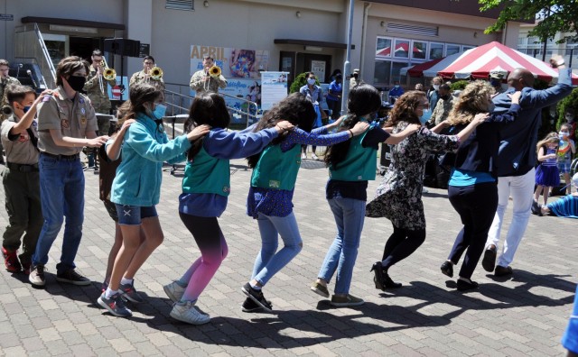 U.S. Army Garrison Japan Army Community Service personnel lead members of the Girl Scouts and Boy Scouts in a conga line during the USAG Japan ACS pinwheel planting commemoration of the month at the Sagamihara Family Housing Area Library, SFHA,...