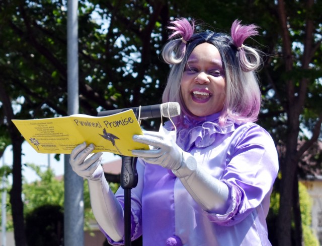 Lucinda Ward, Relocation Readiness Program and volunteer manager at U.S. Army Garrison Japan Army Community Service, dressed as “Clowndia the Clown Fairy,” reads “Pinwheel Promise” by Cindy Lee Morita and illustrated by Melody Dix during...