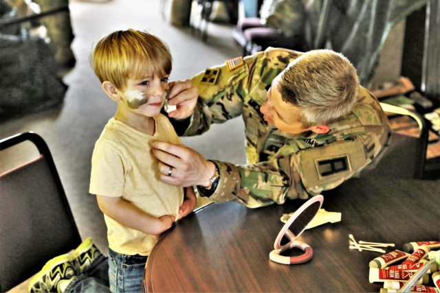 A child has his face painted by a Soldier with the 181st Multi-Functional Training Brigade in building 905 on May 19, 2018, during the 2018 Fort McCoy Armed Forces Day Open House. An estimated 4,000 people or more attended the open house. The open house was held on the grounds of Fort McCoy’s historic Commemorative Area, which includes World War II-era buildings, the Equipment Park, and Veterans Memorial Plaza. People lined up for camouflage face painting, personalized ID tags, an interactive-marksmanship gallery, and military-vehicle and fire-truck displays. They also saw the latest Army medical equipment in use, filled sandbags to build a mock defensive position, and more. (U.S. Army Photo by Scott T. Sturkol, Public Affairs Office, Fort McCoy, Wis.)