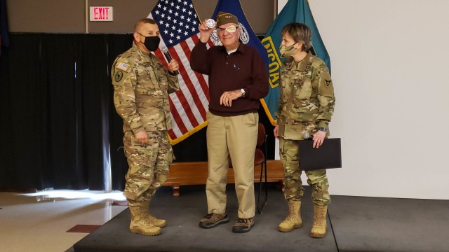 Tom Sitter (center), World War II veteran and Days of Remembrance speaker shows off the coin he received from Maj. Gen. Miguel A. Castellanos (left), commanding general, 84th Training Command, accompanied by Brig. Gen. Stacy Babcock, commanding...