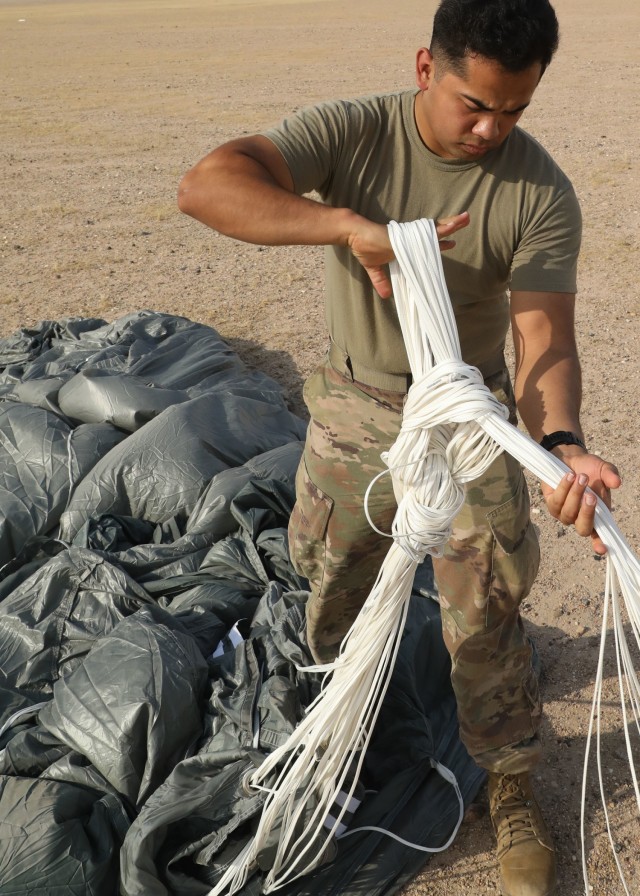 Rigger Spc. Andres Sanchez with the Fort Bragg, North Carolina, based 151st Quartermaster Company, deployed to the U.S. Central Command area of responsibility in support 1st Theater Sustainment Command, collects the rigging lines from one of the four parachutes that successfully carried bundles within 75 meters of the target at the Camp Buehring, Kuwait, drop zone April 22, 2021 using the Joint Precision Air Delivery System, or JPADS. Sanchez said he appreciated the chance to participate in the real-world exercise. (U.S. Army photo by Staff Sgt. Neil W. McCabe)