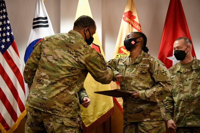 CAMP HUMPHREYS, Republic of Korea - Command Sgt. Maj. Benjamin C. Lemon Jr., left, the senior enlisted advisor for United States Army Garrison Humphreys, bumps elbows with Maj. Jamila Williams, an Eighth Army officer who volunteers with the United Service Organizations - Sentry Village, after presenting her with the Active Duty Category Volunteer of the Year award here, April 20. Williams is the center representative shift leader and the lead volunteer special events planner for the USO-Sentry Village, demonstrating the commitment that many active duty Soldiers have in dedicated their free time to volunteer for the community. (U.S. Army photo by Spc. Matthew Marcellus)