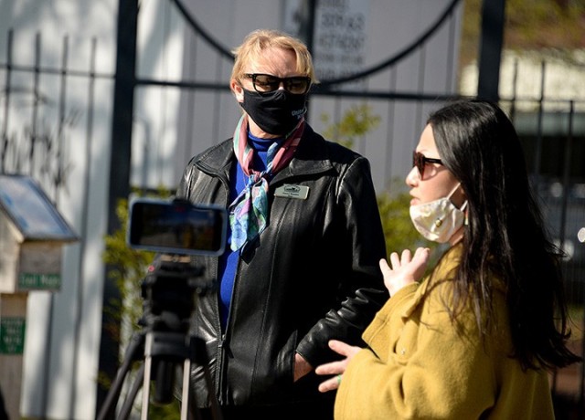Leavenworth Mayor Nancy Bauder listens to "To Be At War" community photography project facilitator Arin Yoon's remarks during the opening of the open-air art exhibit featuring Yoon's portraits of service members and workshop participants'...