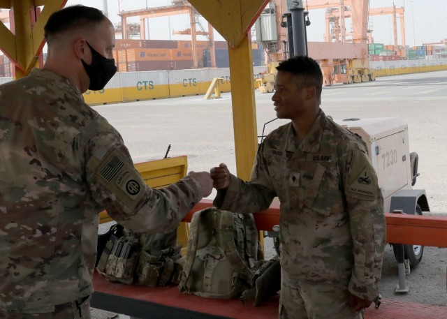 Army Reserve Brig. Gen. Justin M. Swanson, the deputy commanding general of the 1st Theater Sustainment Command, fist pumps Spc. Demarcus Russ after the general's April 24, 2021 tour of port operation at Kuwait's Port Shuaiba. The general was thanking Soldiers for providing security during offload and onload operations, when the New Orleans native learned that the specialist with the 1st Armored Division Soldier grew up in Jonesville, Louisiana. (U.S. Army photo by Sgt. Staff Neil W. McCabe)