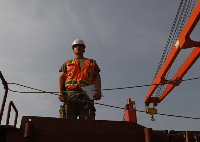Army Reserve Staff Sgt. Armando Ramirez, deployed to Kuwait with the Lancaster, Pennsylvania, based 1185th Deployment and Distribution Support Battalion, watches the April 24, 2021 onload of shipping containers of ammunition aboard the Military Sealift Command container ship Sagamore at Kuwait's Port Shuaiba. Ramirez, who is a civilian fork truck driver at the Port of Long Beach, California, said he focused on safely loading the containers to protect the ship and its crew. (U.S. Army photo by Staff Sgt. Neil W. McCabe)