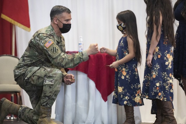 Jaelene Falkenberg, 6, receives a challenge coin from Maj. Gen. Sean Bernabe, the 1st Armored Division and Fort Bliss commanding general, during the 2021 Fort Bliss Annual Volunteer Ceremony at Fort Bliss, Texas, April 22, 2021. Falkenberg is a member of one of three military families that were recognized for their dedication to volunteerism. (U.S. Army photo by David Poe, Fort Bliss Public Affairs)