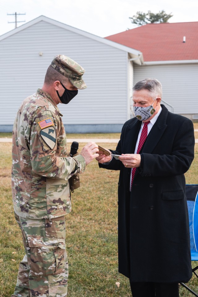 Col. Dave Woodruff, the commander of the 181st Multifunctional Training Brigade, hands Walter Haag, a 37-year Army Reserves veteran, an Eagle Brigade commemorative coin and tree ornament, Dec. 17, 2020, at Fort McCoy, Wis.  Haag was drafted for...